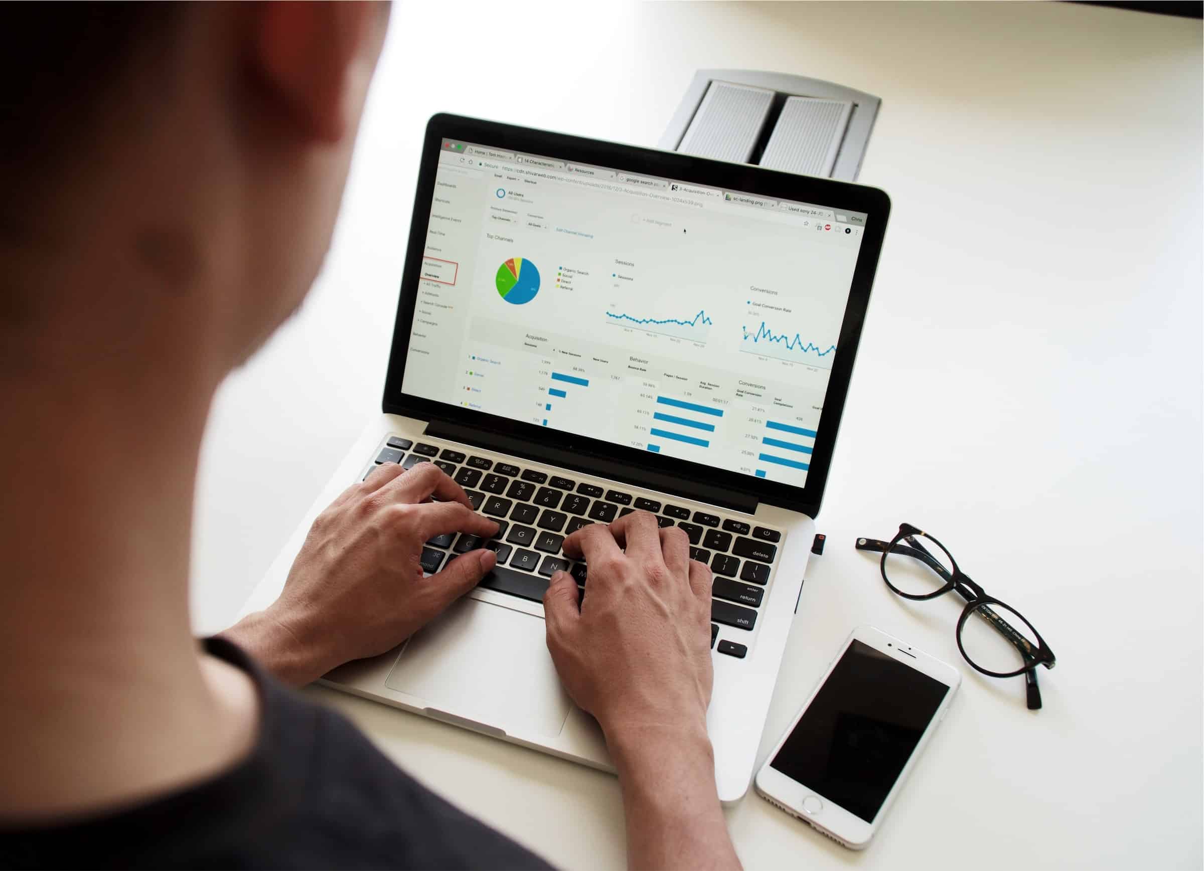 Male digital marketing professional analyzes ad performance data on Google Analytics.