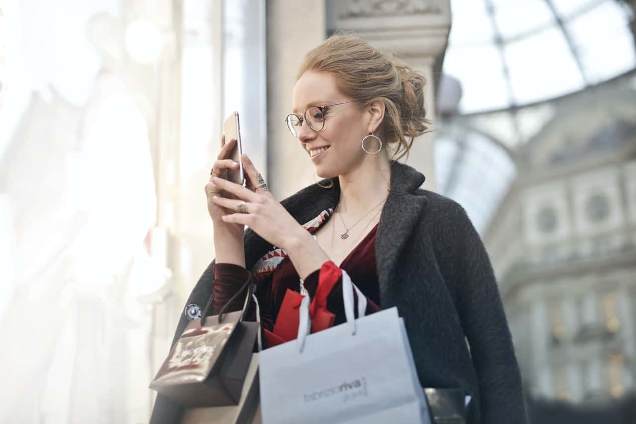 Women shops and makes an online purchase from a paid ad she received on her smartphone.